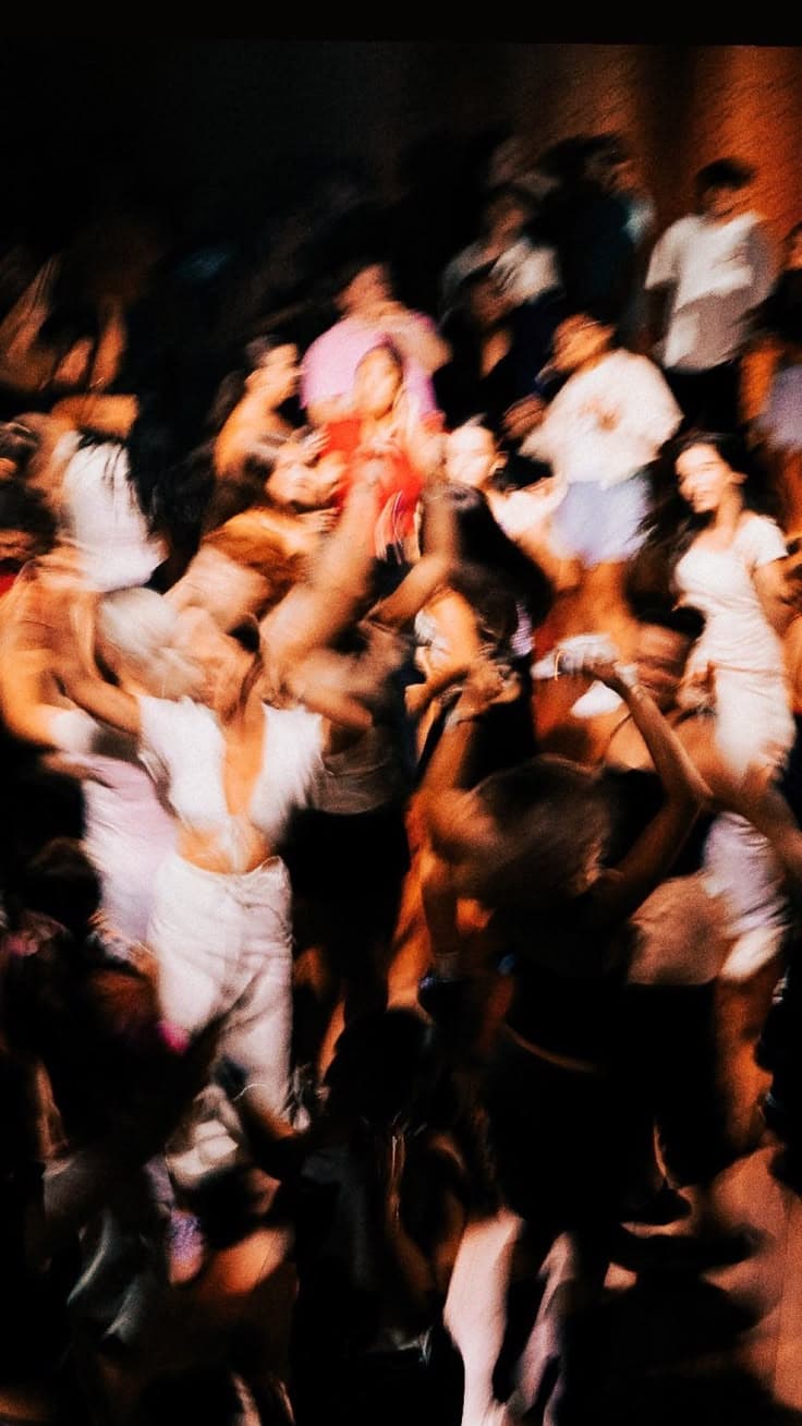 A crowd dancing on a busy night, blurred with movement